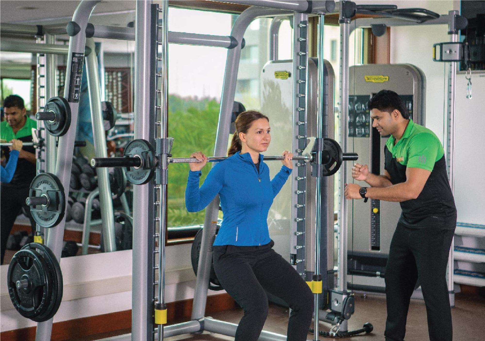 Jumeirah Messilah Beach Kuwait Kuwait City Luaran gambar A personal trainer assisting a woman with a weight training exercise